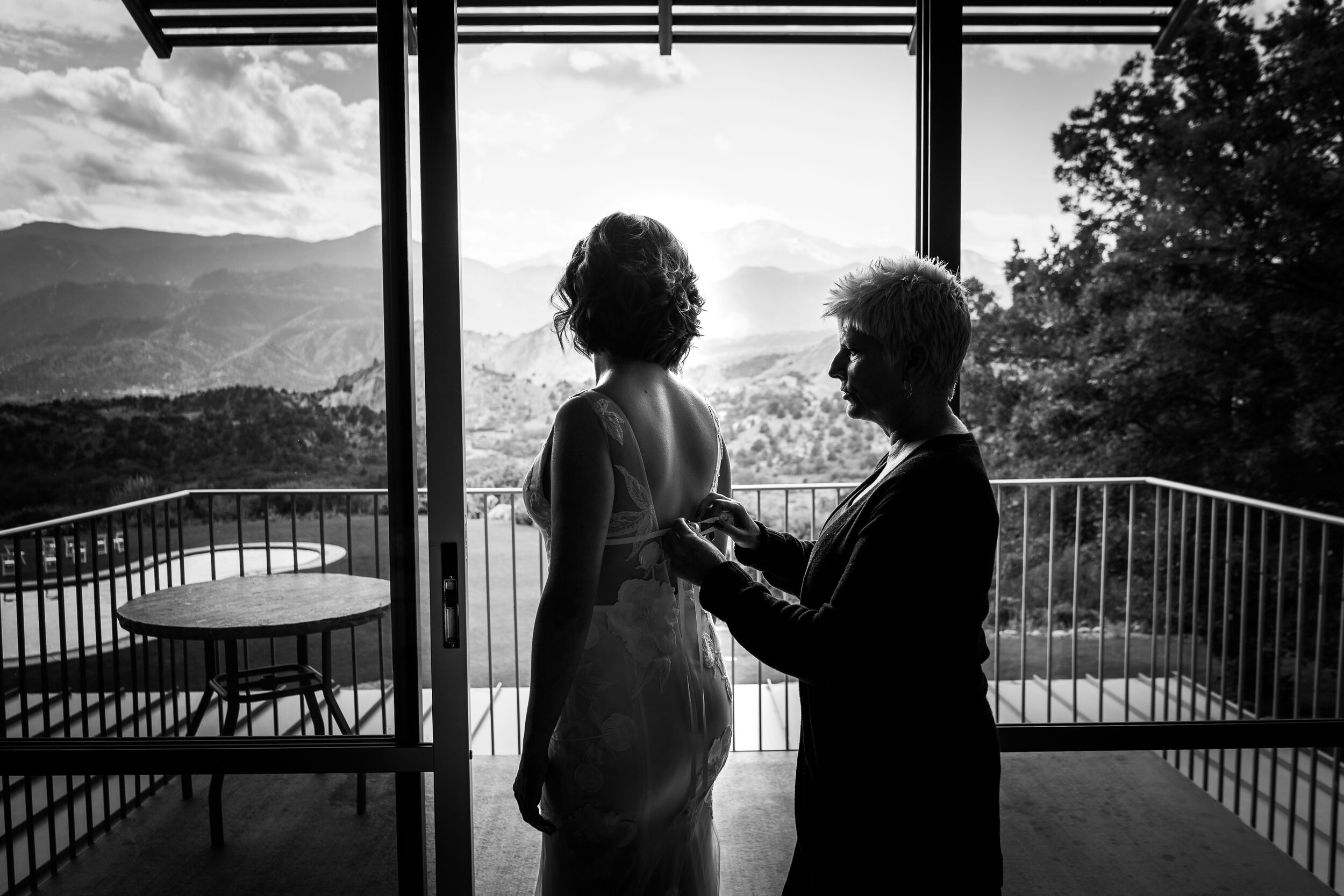 Bride's mom helps her into her wedding gown with the Garden of the Gods Park in the background, wedding photos, wedding photography, wedding photographer, wedding inspiration, wedding photo inspiration, wedding portraits, wedding ceremony, wedding reception, mountain wedding, Garden of the Gods wedding, Garden of the Gods Club & Resort wedding, Garden of the Gods Club & Resort wedding photos, Garden of the Gods Club & Resort wedding photography, Garden of the Gods Club & Resort wedding photographer, Garden of the Gods Club & Resort wedding inspiration, Garden of the Gods Club & Resort wedding venue, Colorado Springs wedding, Colorado Springs wedding photos,  Colorado Springs wedding photography, Colorado Springs wedding photographer, Colorado wedding, Colorado wedding photos, Colorado wedding photography, Colorado wedding photographer, Colorado mountain wedding, Colorado wedding inspiration