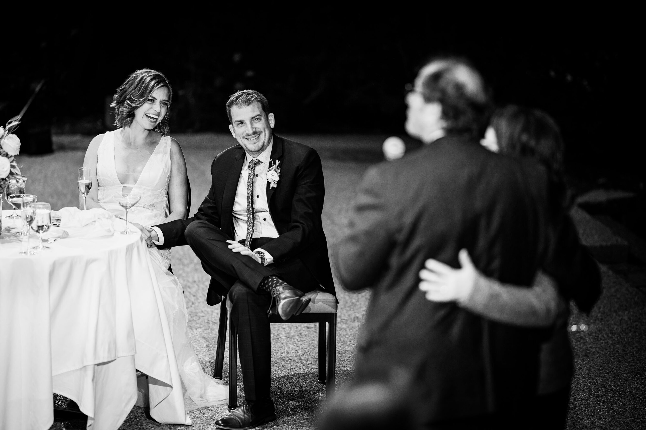 Bride and groom listen to speeches by family and friends during their wedding reception at the Garden of the Gods Club and resort by the reflection pond, wedding photos, wedding photography, wedding photographer, wedding inspiration, wedding photo inspiration, wedding portraits, wedding ceremony, wedding reception, mountain wedding, Garden of the Gods wedding, Garden of the Gods Club & Resort wedding, Garden of the Gods Club & Resort wedding photos, Garden of the Gods Club & Resort wedding photography, Garden of the Gods Club & Resort wedding photographer, Garden of the Gods Club & Resort wedding inspiration, Garden of the Gods Club & Resort wedding venue, Colorado Springs wedding, Colorado Springs wedding photos,  Colorado Springs wedding photography, Colorado Springs wedding photographer, Colorado wedding, Colorado wedding photos, Colorado wedding photography, Colorado wedding photographer, Colorado mountain wedding, Colorado wedding inspiration