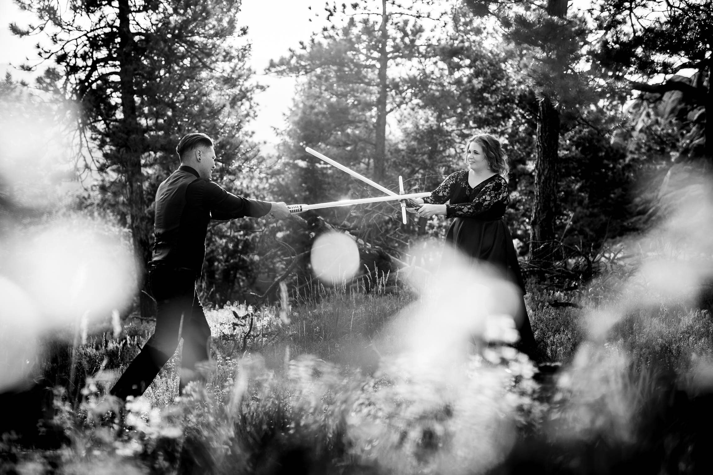 Engaged couple jumps into cosplay with their light sabers in the forest during golden hour, Engagement Session, Engagement Photos, Engagement Photos Inspiration, Engagement Photography, Engagement Photographer, Summer Engagement Photos, Mountain Engagement Photos, Lost Gulch Overlook engagement session, Lost Gulch Overlook engagement photos, Lost Gulch Overlook engagement photography, Lost Gulch Overlook engagement photographer, Lost Gulch Overlook  engagement inspiration, Boulder engagement session, Boulder engagement photos, Boulder engagement photography, Boulder engagement photographer, Boulder engagement inspiration, Colorado engagement session, Colorado engagement photos, Colorado engagement photography, Colorado engagement photographer, Colorado engagement inspiration