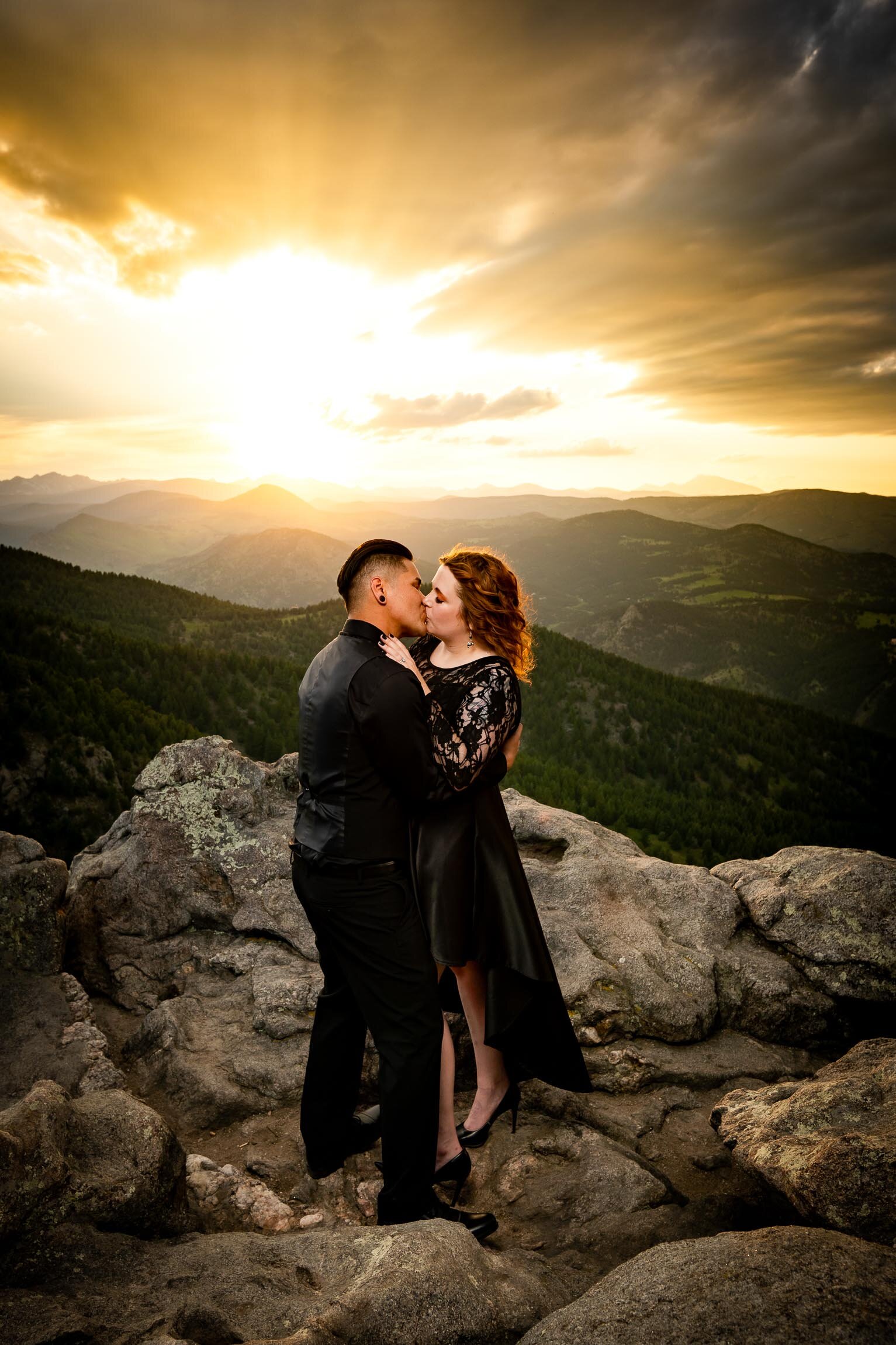 Engaged couple holds hands and watches the sun set from rocky ledge overlooking the mountains, Engagement Session, Sunset Engagement photos, Engagement Photos, Engagement Photos Inspiration, Engagement Photography, Engagement Photographer, Summer Engagement Photos, Mountain Engagement Photos, Lost Gulch Overlook engagement session, Lost Gulch Overlook engagement photos, Lost Gulch Overlook engagement photography, Lost Gulch Overlook engagement photographer, Lost Gulch Overlook  engagement inspiration, Boulder engagement session, Boulder engagement photos, Boulder engagement photography, Boulder engagement photographer, Boulder engagement inspiration, Colorado engagement session, Colorado engagement photos, Colorado engagement photography, Colorado engagement photographer, Colorado engagement inspiration