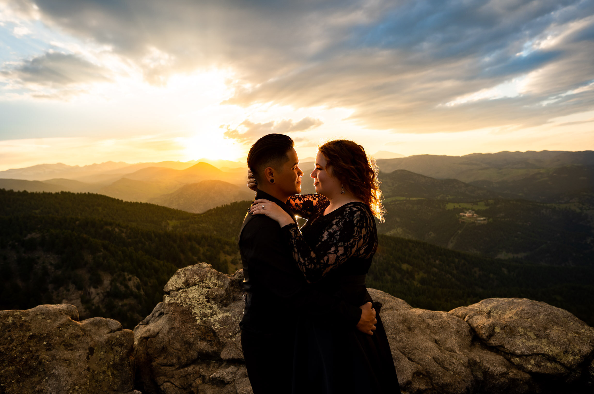 Engaged couple holds hands and watches the sun set from rocky ledge overlooking the mountains, Engagement Session, Sunset Engagement photos, Engagement Photos, Engagement Photos Inspiration, Engagement Photography, Engagement Photographer, Summer Engagement Photos, Mountain Engagement Photos, Lost Gulch Overlook engagement session, Lost Gulch Overlook engagement photos, Lost Gulch Overlook engagement photography, Lost Gulch Overlook engagement photographer, Lost Gulch Overlook  engagement inspiration, Boulder engagement session, Boulder engagement photos, Boulder engagement photography, Boulder engagement photographer, Boulder engagement inspiration, Colorado engagement session, Colorado engagement photos, Colorado engagement photography, Colorado engagement photographer, Colorado engagement inspiration