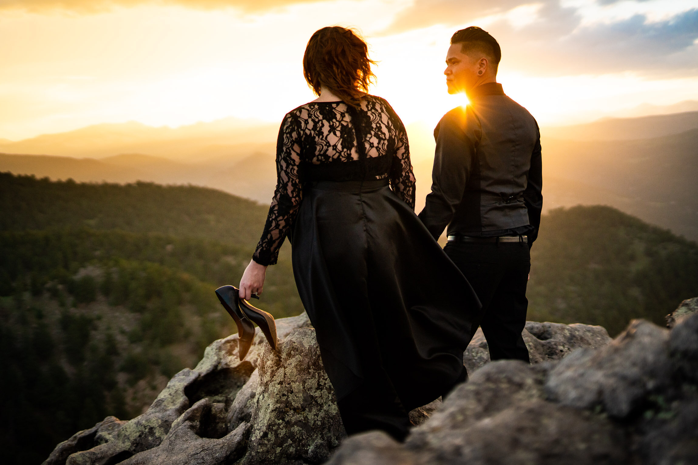 Engaged couple holds hands and watches the sun set from rocky ledge overlooking the mountains, Engagement Session, Sunset Engagement photos, Engagement Photos, Engagement Photos Inspiration, Engagement Photography, Engagement Photographer, Summer Engagement Photos, Mountain Engagement Photos, Lost Gulch Overlook engagement session, Lost Gulch Overlook engagement photos, Lost Gulch Overlook engagement photography, Lost Gulch Overlook engagement photographer, Lost Gulch Overlook  engagement inspiration, Boulder engagement session, Boulder engagement photos, Boulder engagement photography, Boulder engagement photographer, Boulder engagement inspiration, Colorado engagement session, Colorado engagement photos, Colorado engagement photography, Colorado engagement photographer, Colorado engagement inspiration