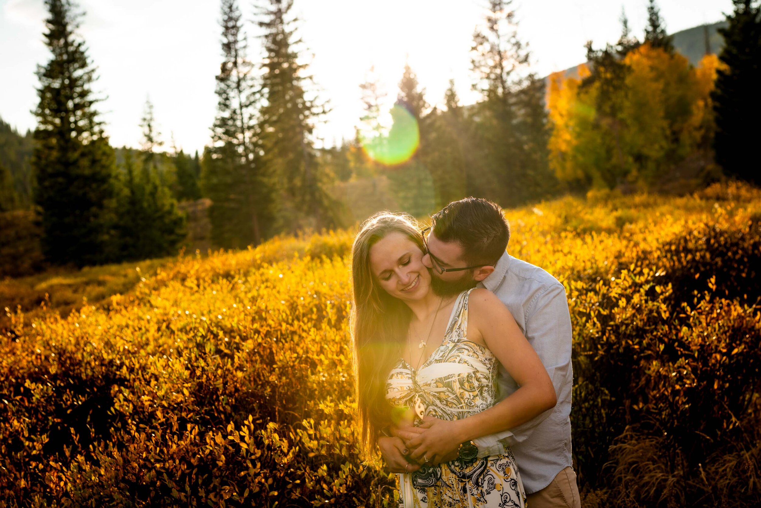 Engaged couple embraces for a portrait in a field of gold during golden hour in the peak of the fall season with foliage all around, Engagement Session, Engagement Photos, Engagement Photos Inspiration, Engagement Photography, Engagement Photographer, Fall Engagement Photos, Mountain Engagement Photos, Piney River Ranch engagement photos, Vail engagement session, Vail engagement photos, Vail engagement photography, Vail engagement photographer, Vail engagement inspiration, Colorado engagement session, Colorado engagement photos, Colorado engagement photography, Colorado engagement photographer, Colorado engagement inspiration