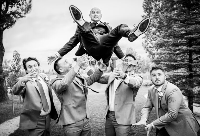 Groomsmen toss the groom in the air